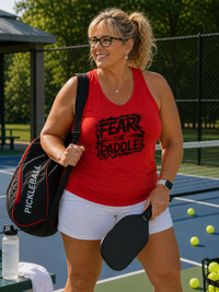 Load image into Gallery viewer, "Woman wearing Fear the Paddle racerback tank top on a pickleball court, sporty performance style"