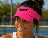 Load image into Gallery viewer, Woman wearing a pink visor with 'Pickleball' streak design on a pickleball court