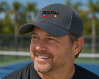 Load image into Gallery viewer, Man wearing a pickleball-themed cap on a court with palm trees in the background